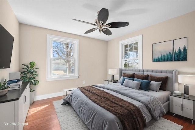 bedroom with baseboards, wood finished floors, and a ceiling fan