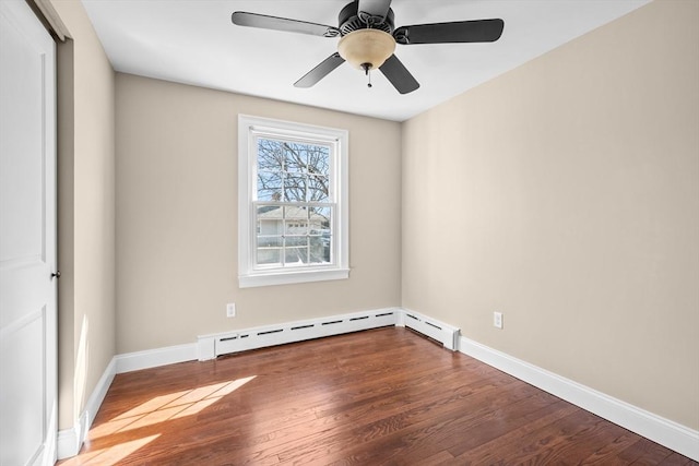 unfurnished room with a baseboard radiator, baseboards, and wood finished floors