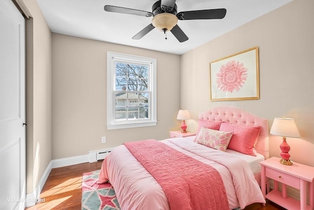 bedroom with ceiling fan, baseboards, and wood finished floors