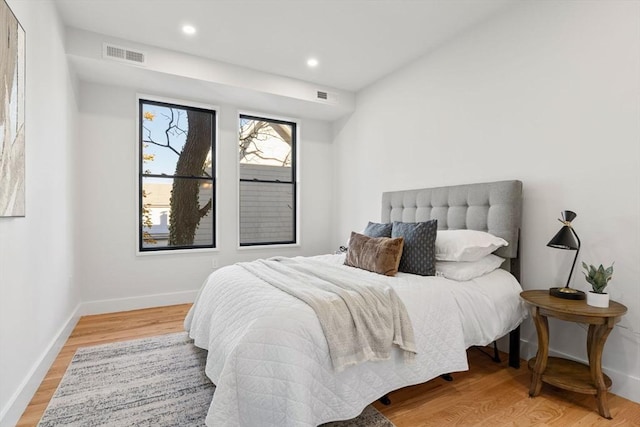 bedroom with recessed lighting, visible vents, baseboards, and wood finished floors