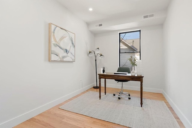 home office with visible vents, baseboards, and wood finished floors