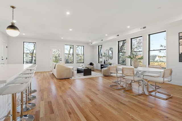 living room with recessed lighting, baseboards, visible vents, and light wood finished floors