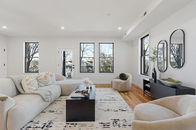 living room featuring light wood-style floors, recessed lighting, and baseboards