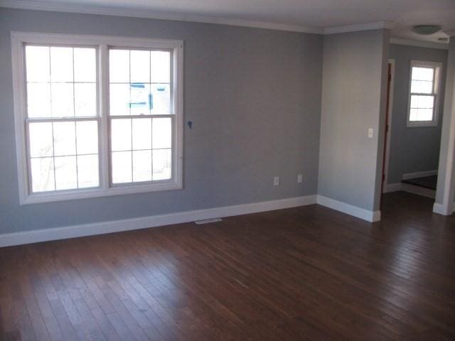 spare room with dark hardwood / wood-style flooring and ornamental molding