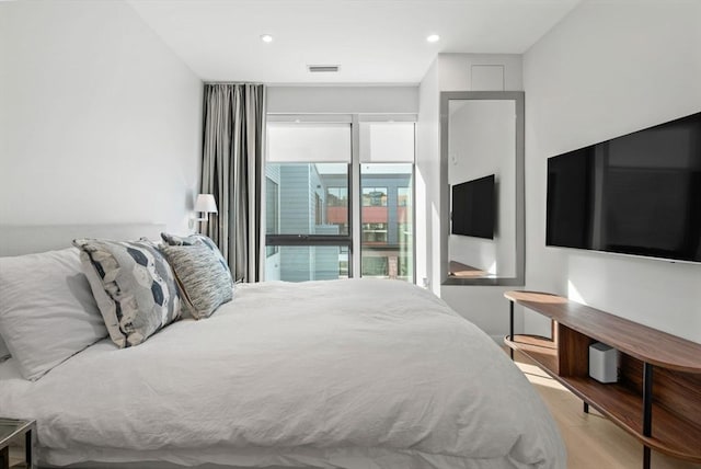 bedroom with access to exterior and light hardwood / wood-style flooring