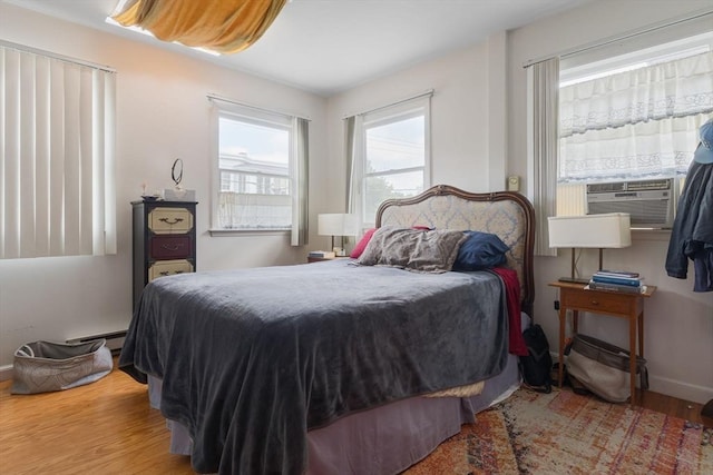 50-52 Chilton St, Cambridge, MA 02138 - bedroom with wood finished floors, cooling unit, and a baseboard radiator