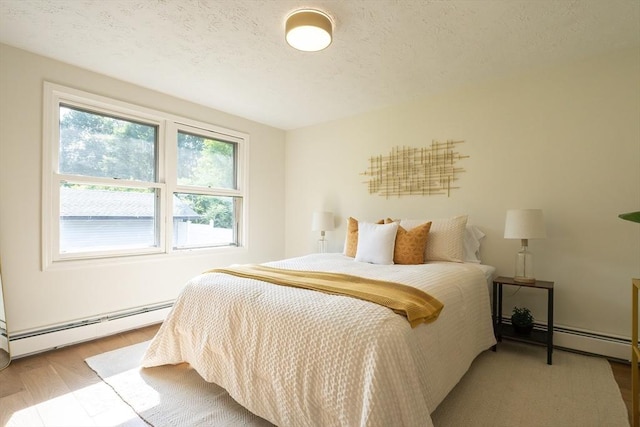 67 Paris Ave, Worcester, MA 01603 - bedroom featuring baseboard heating, wood finished floors, and a textured ceiling