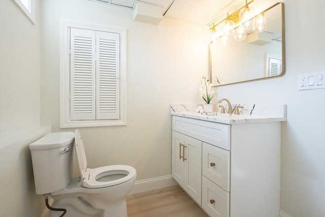 67 Paris Ave, Worcester, MA 01603 - bathroom with toilet, vanity, wood finished floors, and baseboards