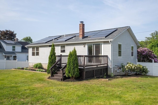 67 Paris Ave, Worcester, MA 01603 - rear view of house featuring a chimney, a wooden deck, roof mounted solar panels, and roof with shingles