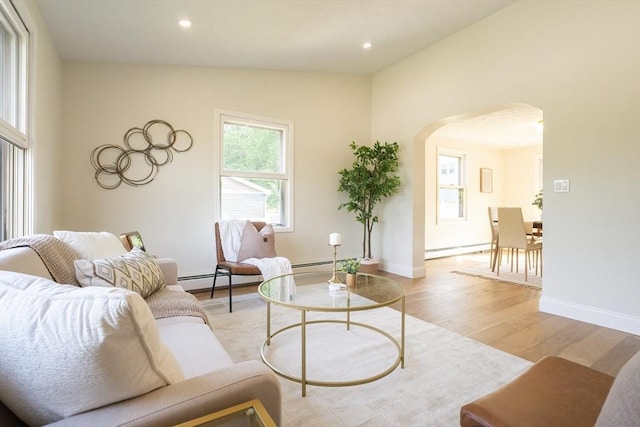 67 Paris Ave, Worcester, MA 01603 - living room featuring arched walkways, a baseboard heating unit, light wood finished floors, baseboards, and recessed lighting