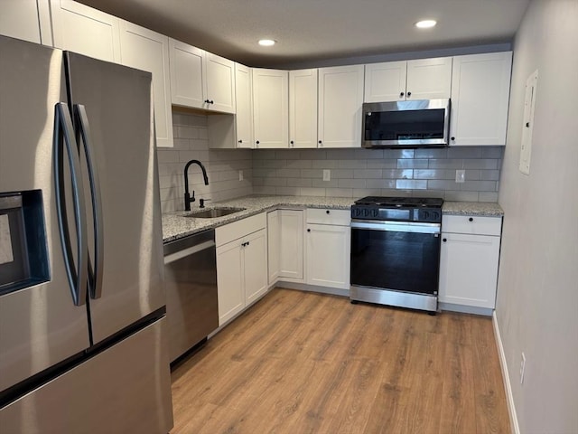 100 Cass Ave Unit B20, Dracut, MA 01826 - kitchen with appliances with stainless steel finishes, light wood-type flooring, white cabinets, decorative backsplash, and recessed lighting
