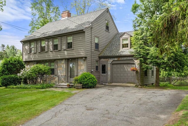 20 Johnson Rd, Andover, MA 01810 - view of front of property with driveway, a chimney, stone siding, roof with shingles, and a garage
