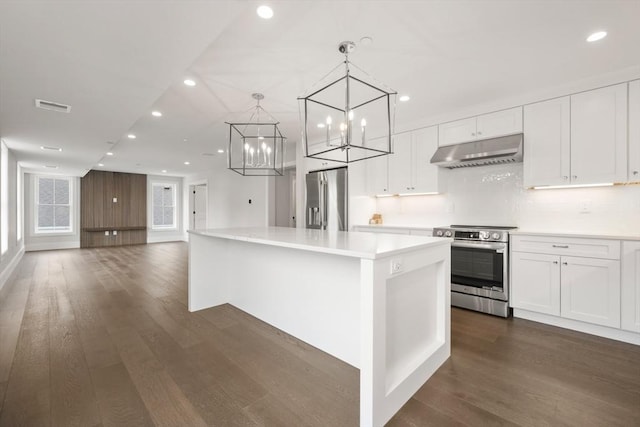 kitchen with recessed lighting, under cabinet range hood, white cabinets, dark wood finished floors, and appliances with stainless steel finishes