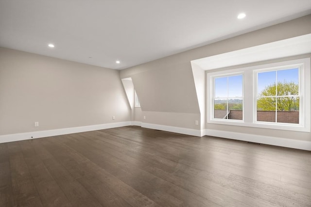 spare room with baseboards, recessed lighting, and dark wood-style flooring