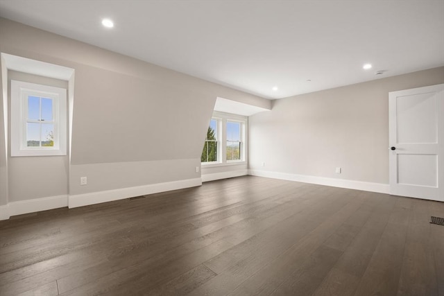 spare room featuring baseboards, recessed lighting, and dark wood-style flooring