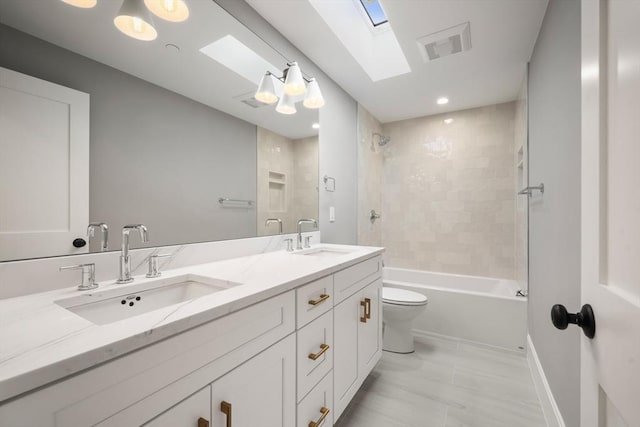 full bathroom featuring a sink, a skylight, toilet, and double vanity