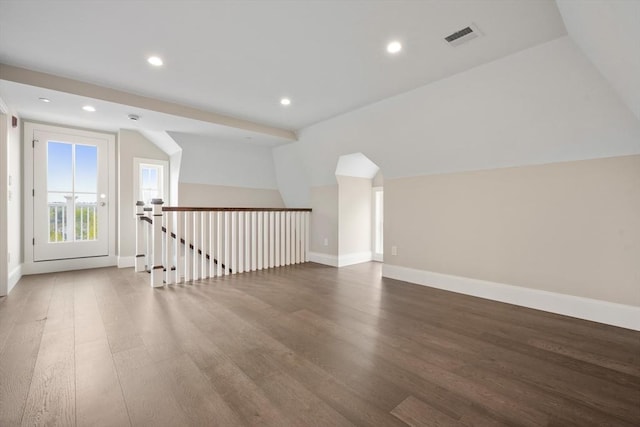 additional living space featuring visible vents, baseboards, lofted ceiling, and wood finished floors