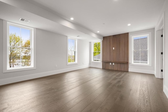 unfurnished living room featuring baseboards, recessed lighting, hardwood / wood-style floors, and visible vents