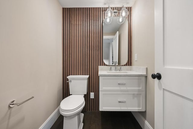 bathroom with vanity, baseboards, and toilet