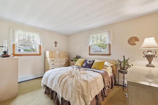 bedroom with a baseboard heating unit, light carpet, multiple windows, and baseboards