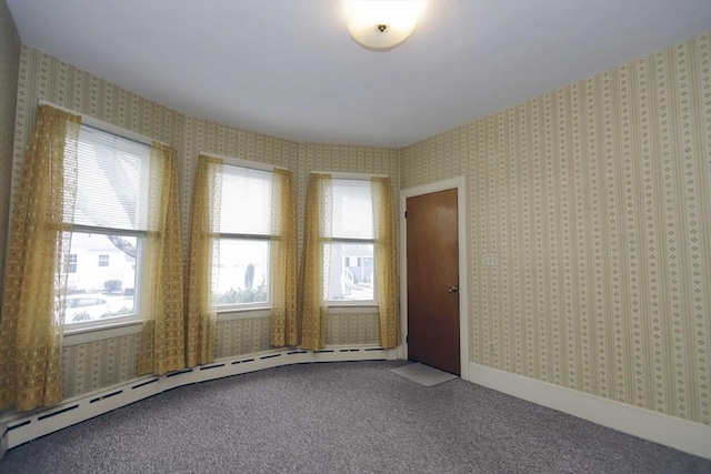 empty room featuring a baseboard radiator and carpet flooring