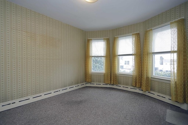 carpeted empty room with baseboard heating