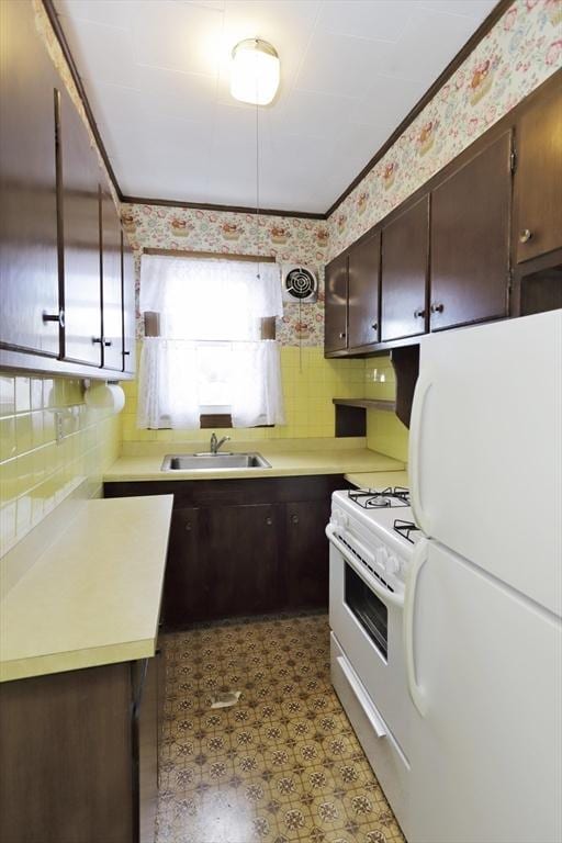 kitchen featuring tasteful backsplash, sink, white appliances, and dark brown cabinets