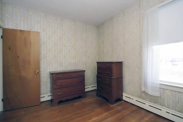 unfurnished bedroom with a baseboard radiator and dark hardwood / wood-style floors