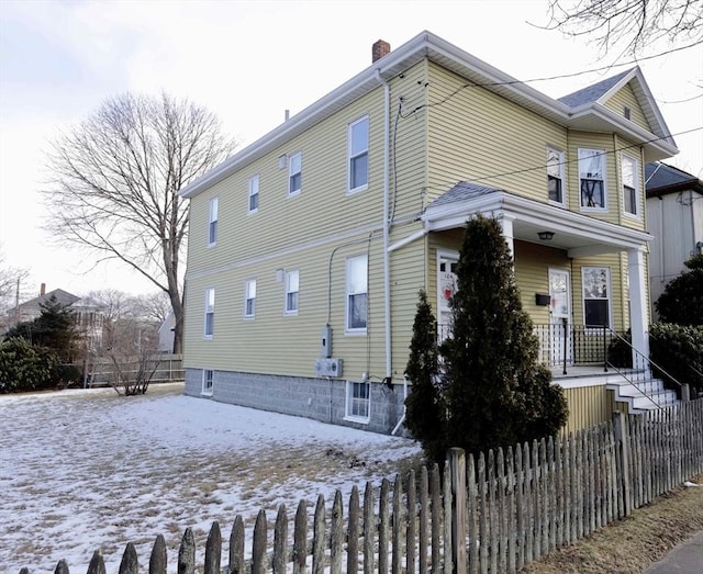 snow covered property with a porch