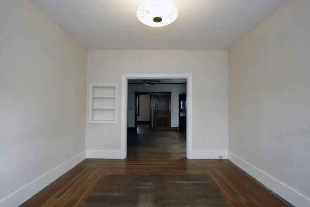 corridor featuring dark wood-type flooring and built in shelves