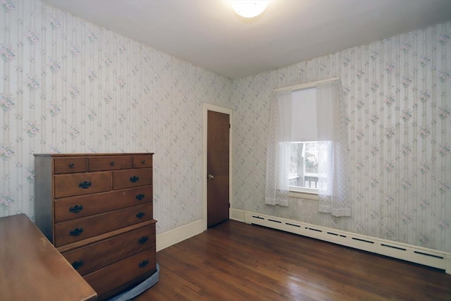 bedroom with dark hardwood / wood-style flooring and a baseboard radiator