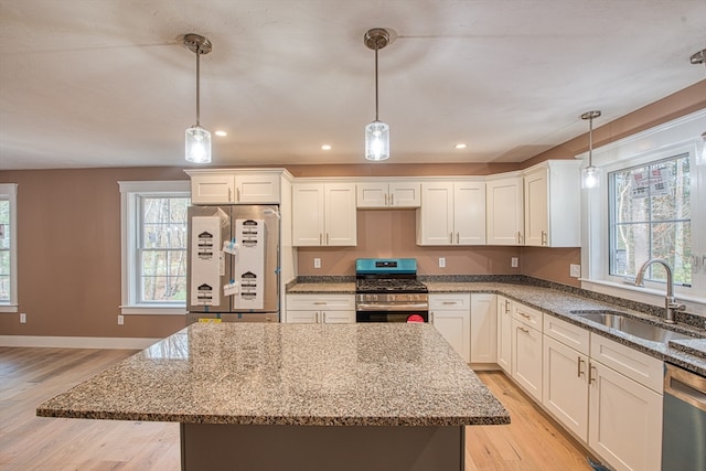 kitchen featuring decorative light fixtures, light hardwood / wood-style floors, and stainless steel appliances