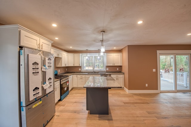 kitchen with plenty of natural light, pendant lighting, appliances with stainless steel finishes, and a center island