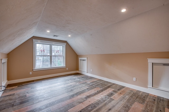 bonus room with lofted ceiling and hardwood / wood-style flooring