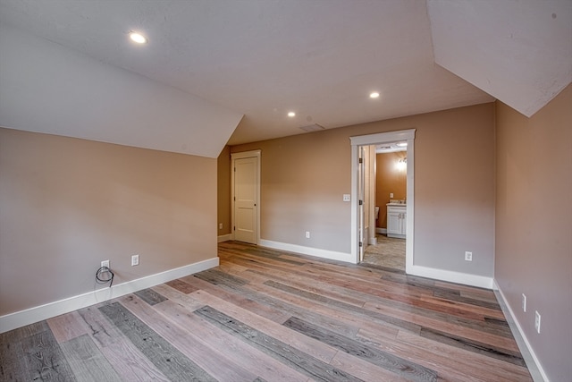 bonus room featuring light wood-type flooring and lofted ceiling