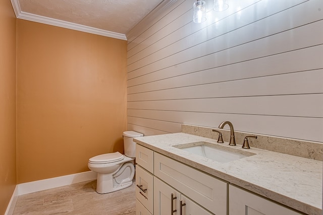 bathroom with toilet, vanity, a textured ceiling, and ornamental molding