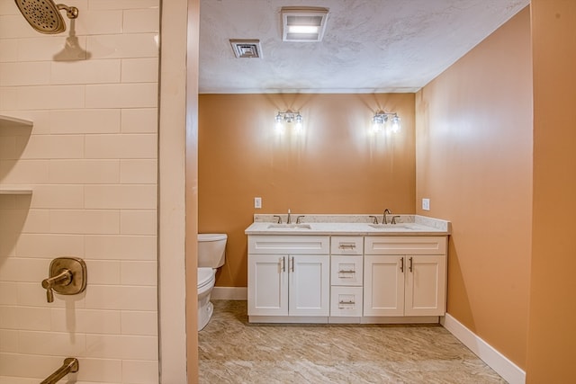 bathroom with a shower, vanity, toilet, and a textured ceiling