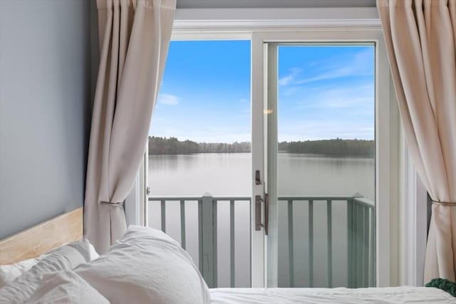 bedroom featuring a water view and multiple windows