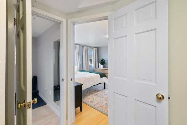bedroom with light wood finished floors and baseboards