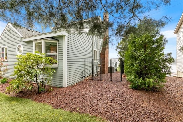 view of side of property with a chimney and fence