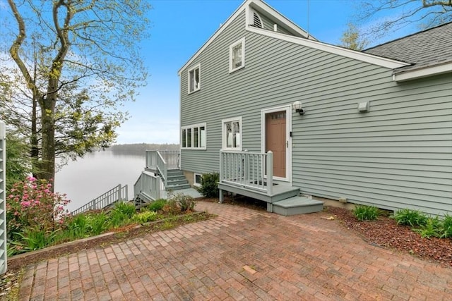 back of property featuring a water view