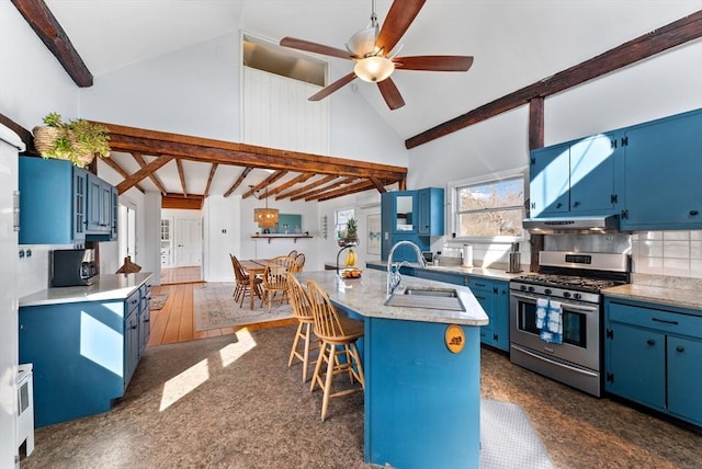 kitchen featuring blue cabinetry, a breakfast bar area, appliances with stainless steel finishes, high vaulted ceiling, and a sink