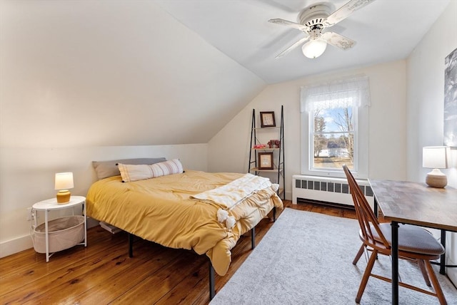 bedroom with lofted ceiling, a ceiling fan, wood finished floors, radiator heating unit, and baseboards