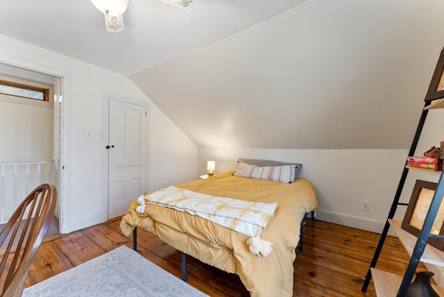 bedroom with hardwood / wood-style floors, vaulted ceiling, and baseboards