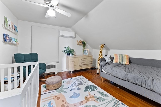 bedroom with a wall mounted air conditioner, wood finished floors, radiator, ceiling fan, and vaulted ceiling