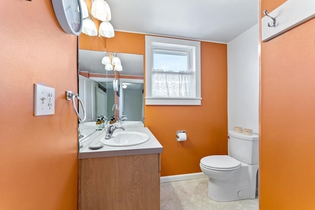 bathroom featuring vanity, toilet, and baseboards