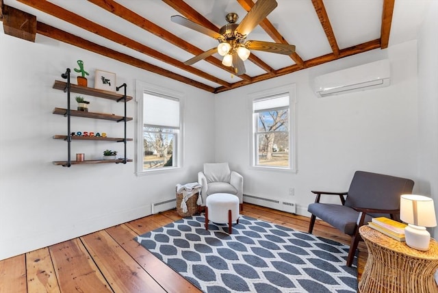 sitting room featuring a wall mounted air conditioner, a baseboard radiator, a healthy amount of sunlight, and hardwood / wood-style floors