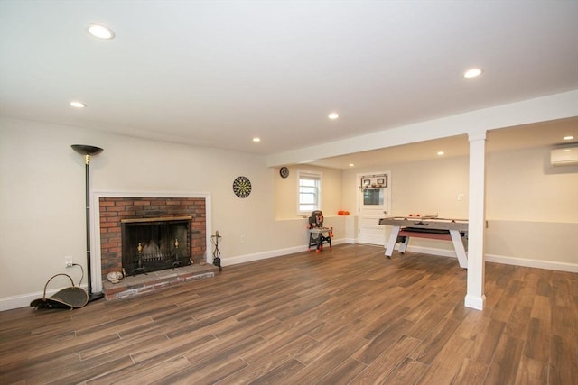 215 Alida Rd, Braintree, MA 02184 - below grade area featuring wood finished floors, recessed lighting, a wall mounted air conditioner, and a brick fireplace