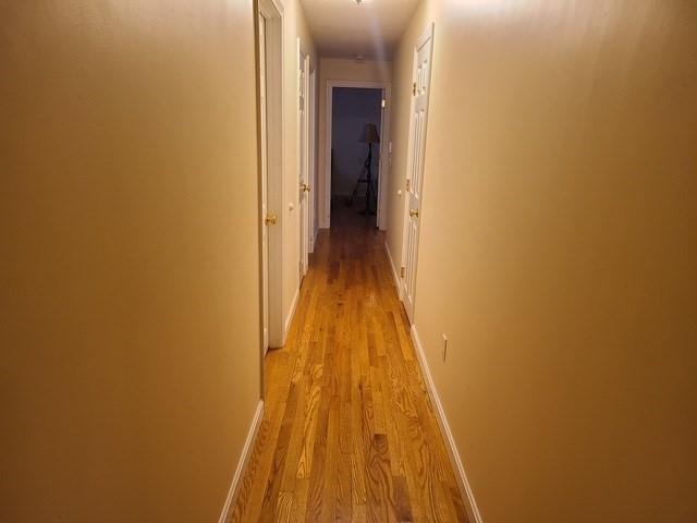 hallway with light wood-style floors and baseboards