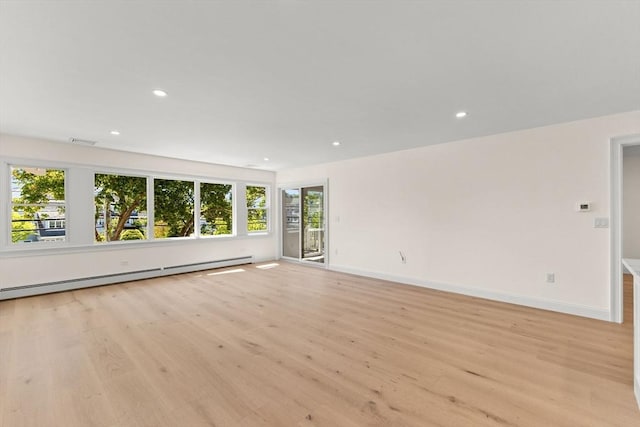 unfurnished room with light wood finished floors, baseboard heating, baseboards, and recessed lighting